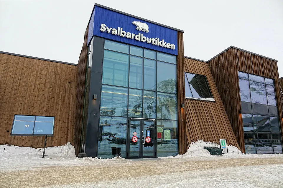 Eingang des Supermarkts Svalbardbutikken in Longyearbyen mit Schnee davor