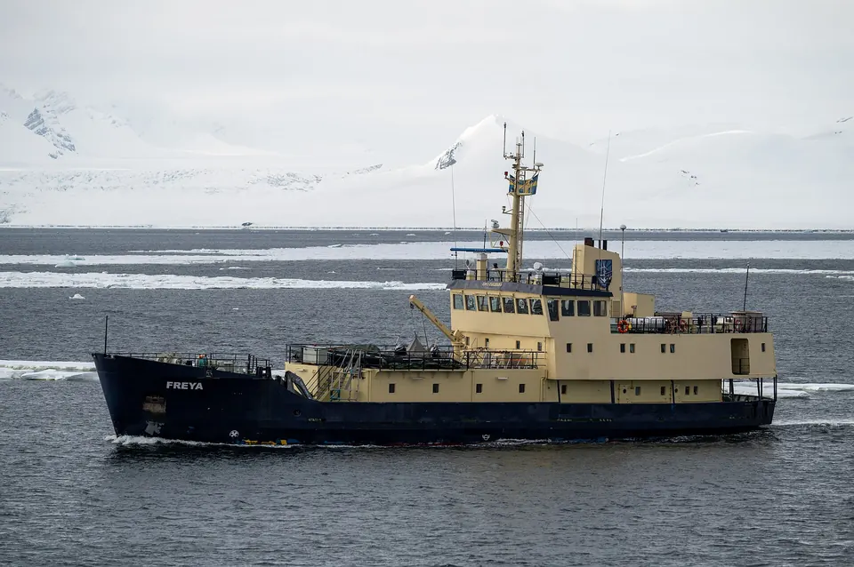 MS Freya -alus Isfjordenilla lumipeitteisten tunturien edessä