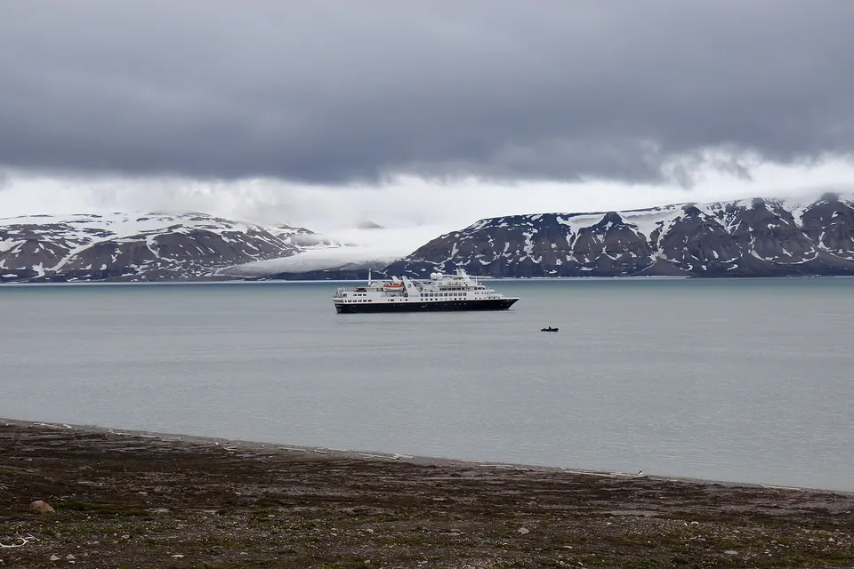 Expeditionsschiff in einem Fjord auf Spitzbergen mit Gletschern und verschneiten Bergen