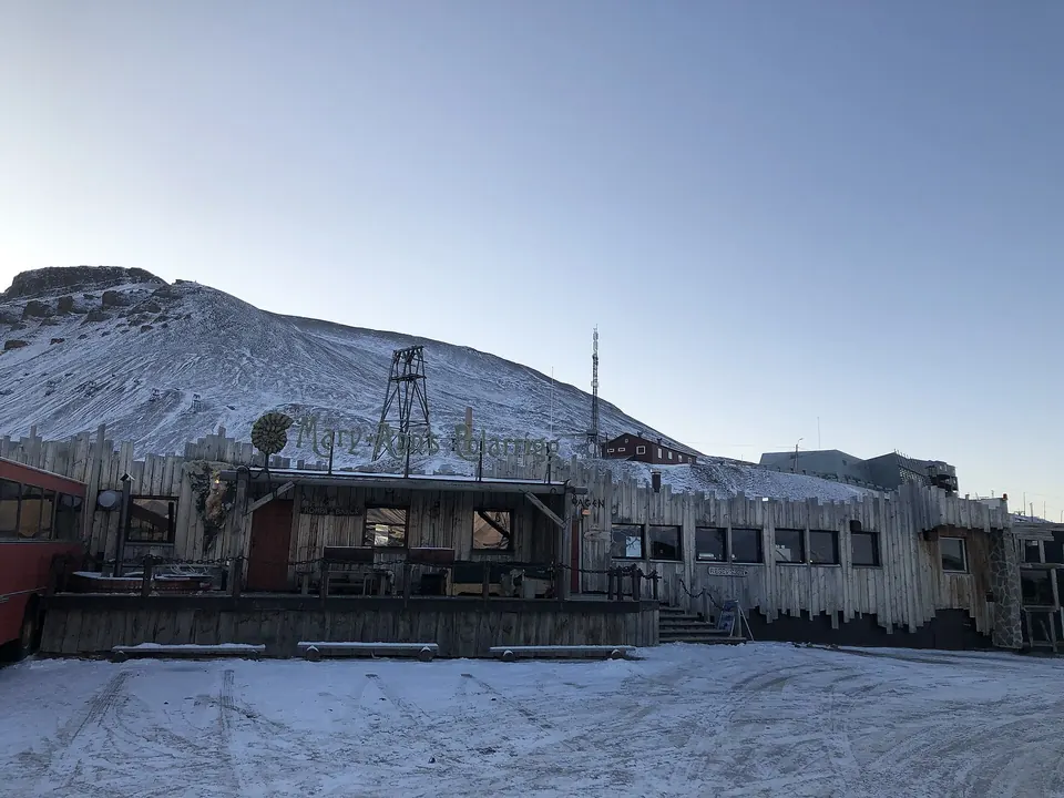 Unterkunft aus Holz in Longyearbyen mit Schnee davor