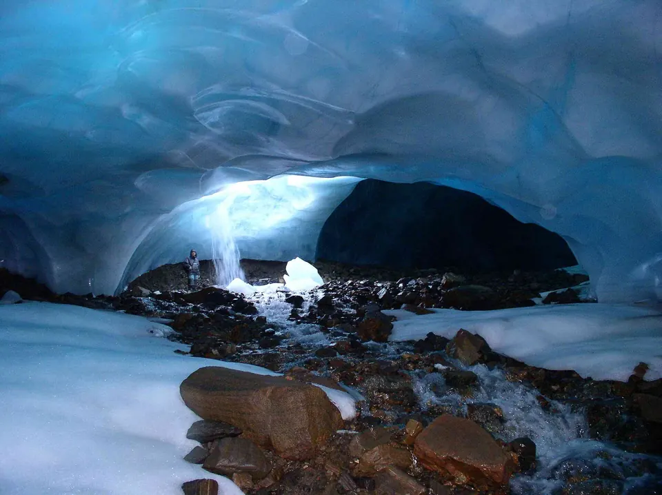 Blauw ijs en bevroren wanden in een smalle ijsgrot onder een gletsjer op Spitsbergen